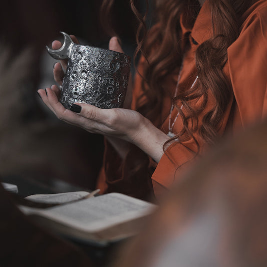 tazza lunare in ceramica da regalo nera con luna tenuta in mano da donna