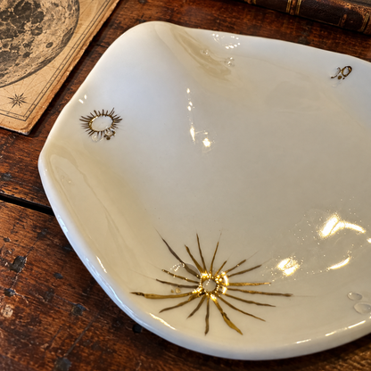 Dettaglio dei raggi dorati di un cratere lunare dipinto a mano sul piatto in ceramica White Lunar Wave