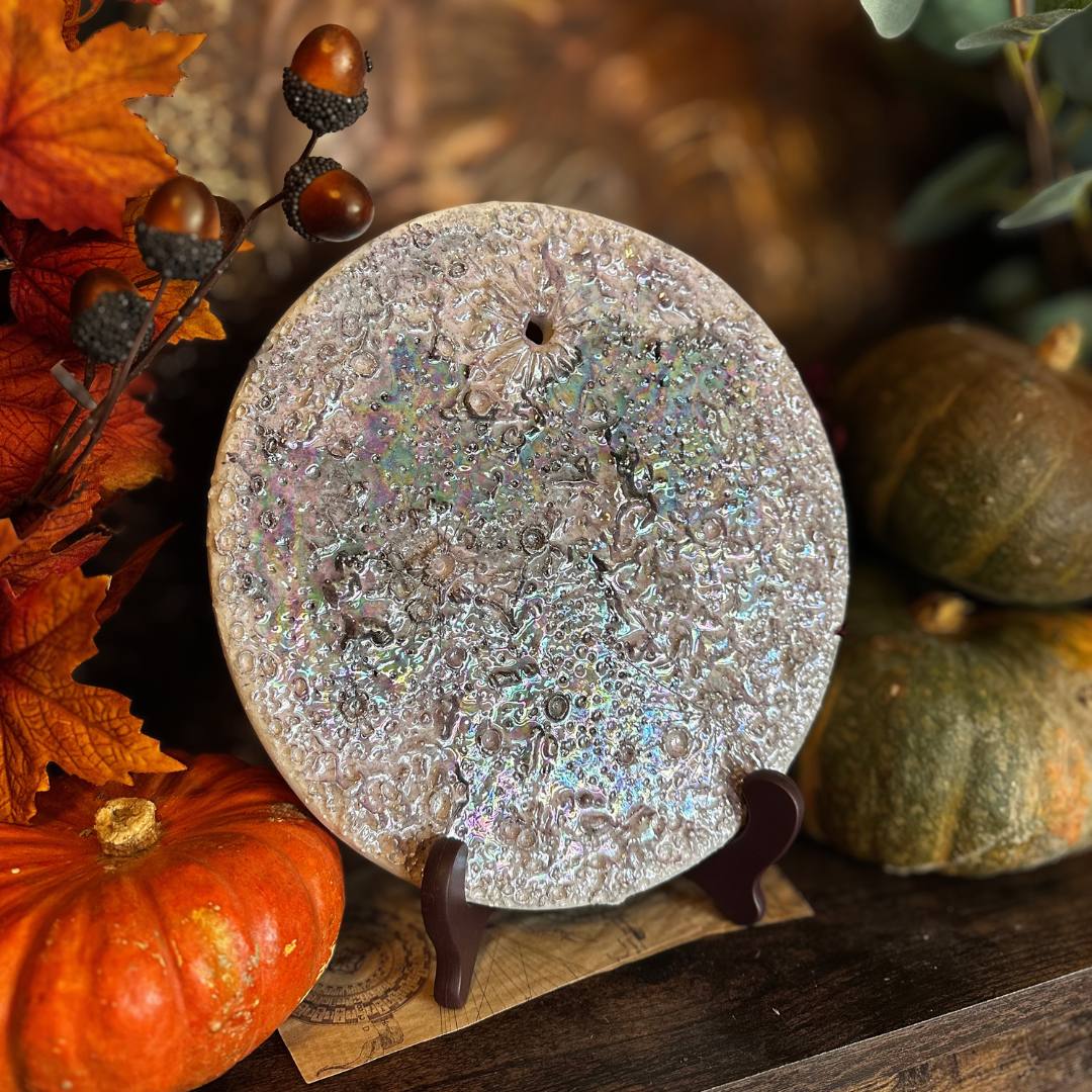 Luna della Soglia grande in ceramica viola su un leggio, fra zucche e foglie d'autunno