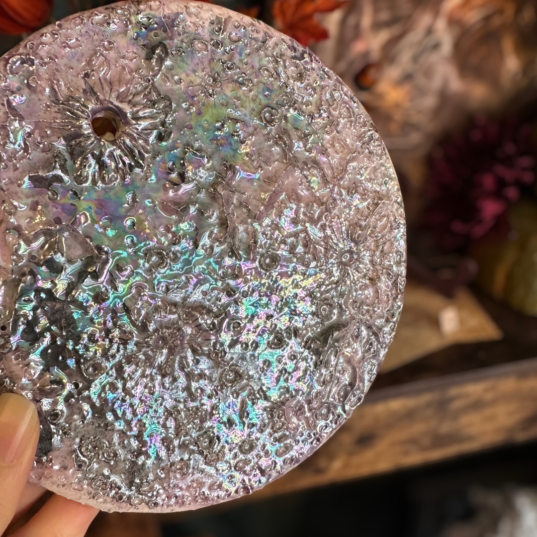 Primo piano della Luna della Soglia V: superficie a crateri con riflessi iridescenti sul viola