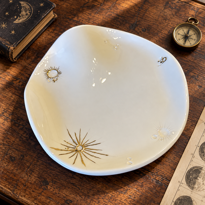 Piatto da portata White Lunar Wave in ceramica bianca con crateri lunari in oro, visto dall'alto su un tavolo di legno scuro