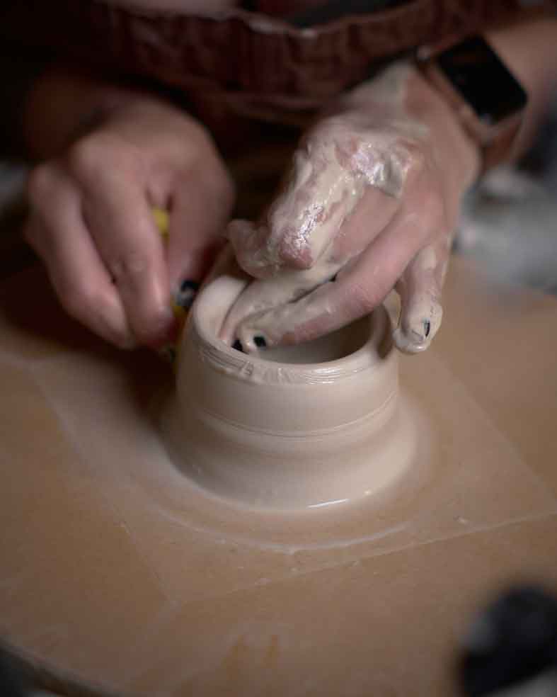 mani che lavorano al tornio