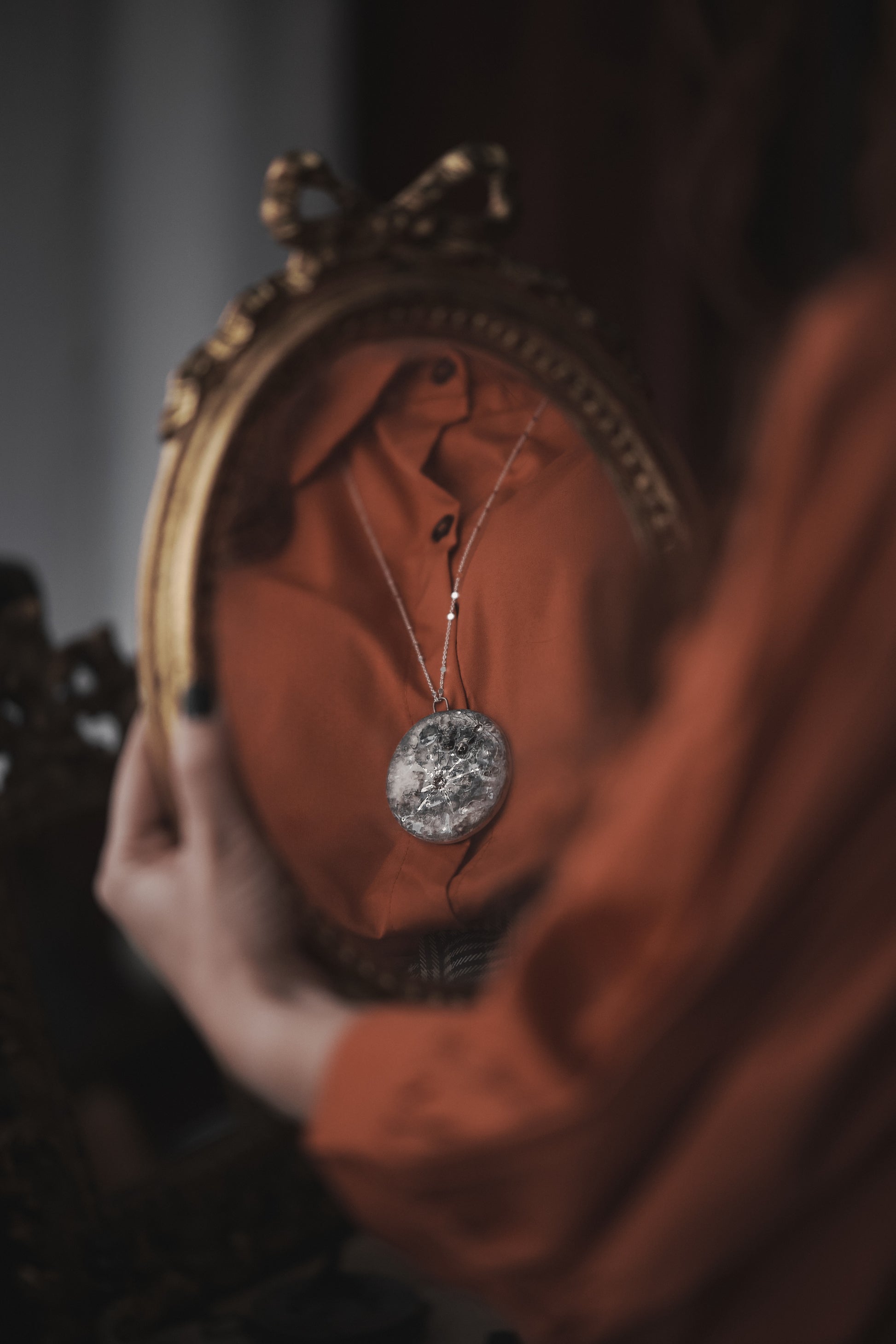 donna che si specchia con collana in ceramica la luna