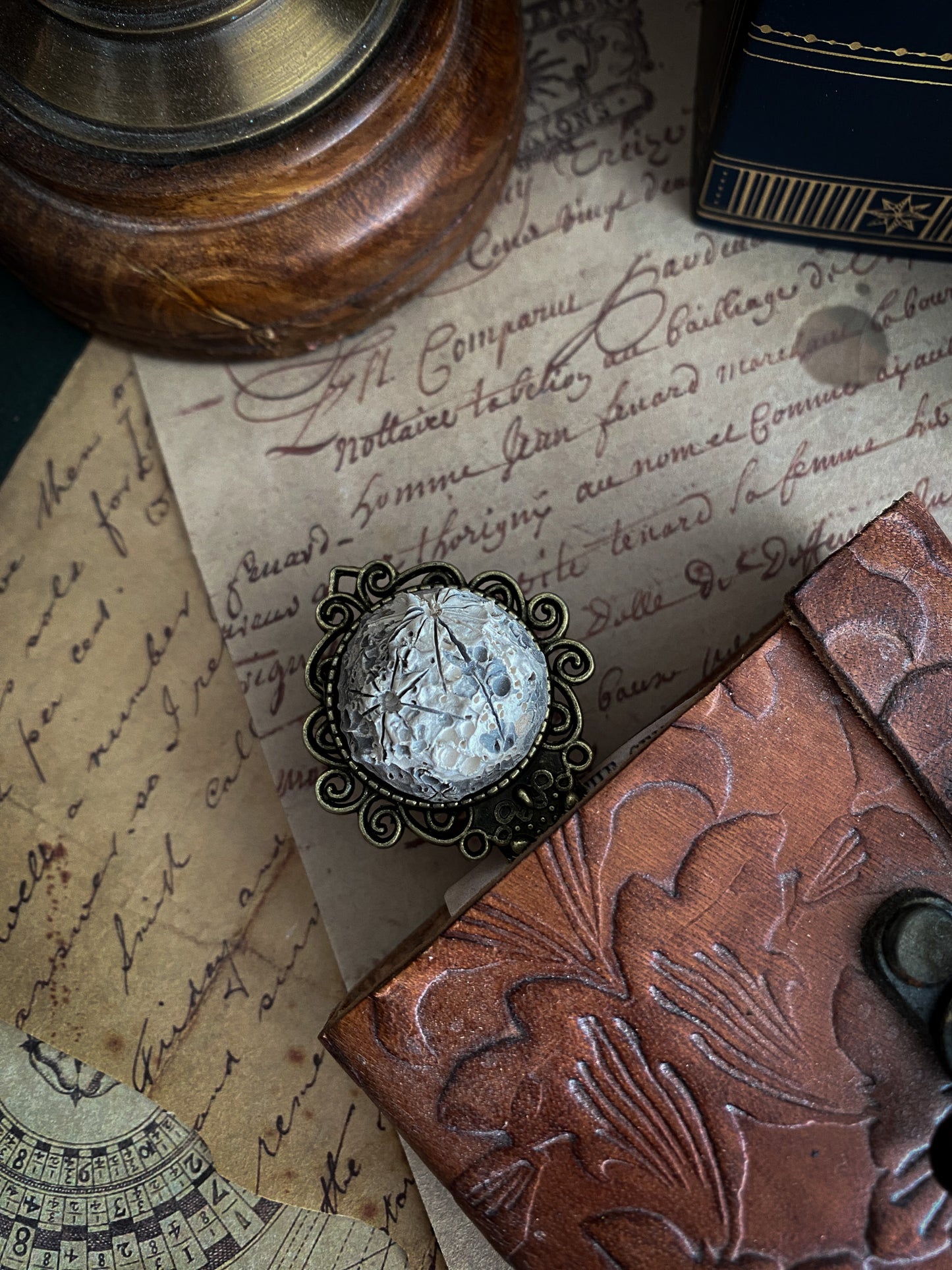 Un antico segnalibro in ceramica evoca storie del passato, adagiato su una lettera dal carattere scritto a mano, promessa di avventure non ancora scoperte.