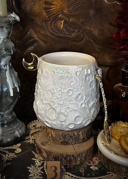Tazza lunare 3 in ceramica fatta a mano accanto a candela e fiori scuri
