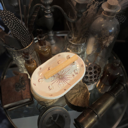 Piattino lunare White and Rose Gold con palo santo, tra boccette e strumenti vintage.